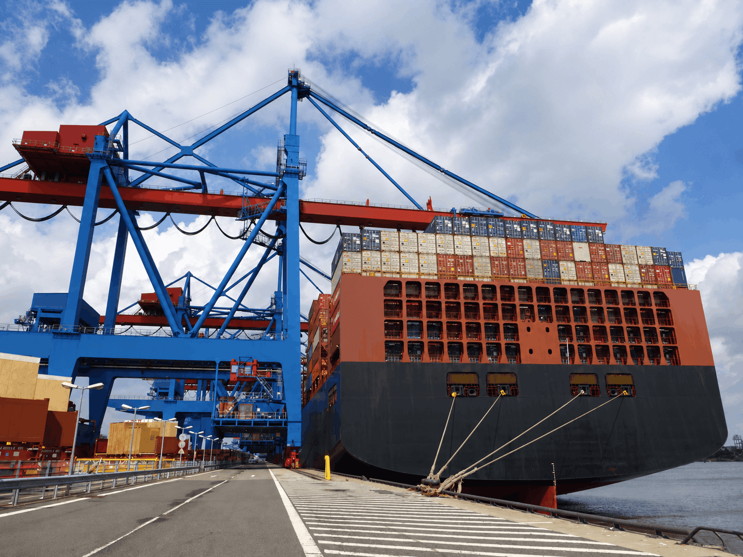 Cargo ship at the port beside container cranes